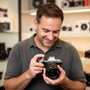 Formador de fotografía revisando una cámara en la tienda